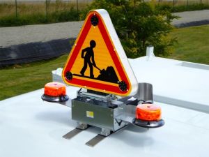 Blinkendes Warnschild „Baustelle“ und Rundumleuchte auf dem Führerhaus